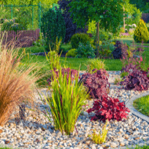 garden design woodstock - Landscaping in Woodstock, GA - Factors to Consider When Designing Your Garden - a garden with grasses and various colourful groundcovers with landscaping gravel for mulch