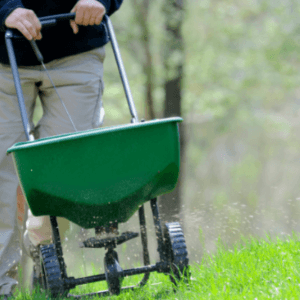 lawn care woodstock ga - The Perfect Lawn How to Get It Green and Keep It That Way - landscaper fertilizing the lawn with a green spreader