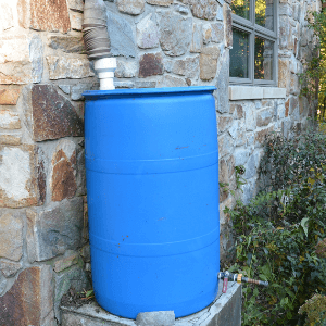 landscape design woodstock ga - a simple setup of a blue drum used as a rain collector